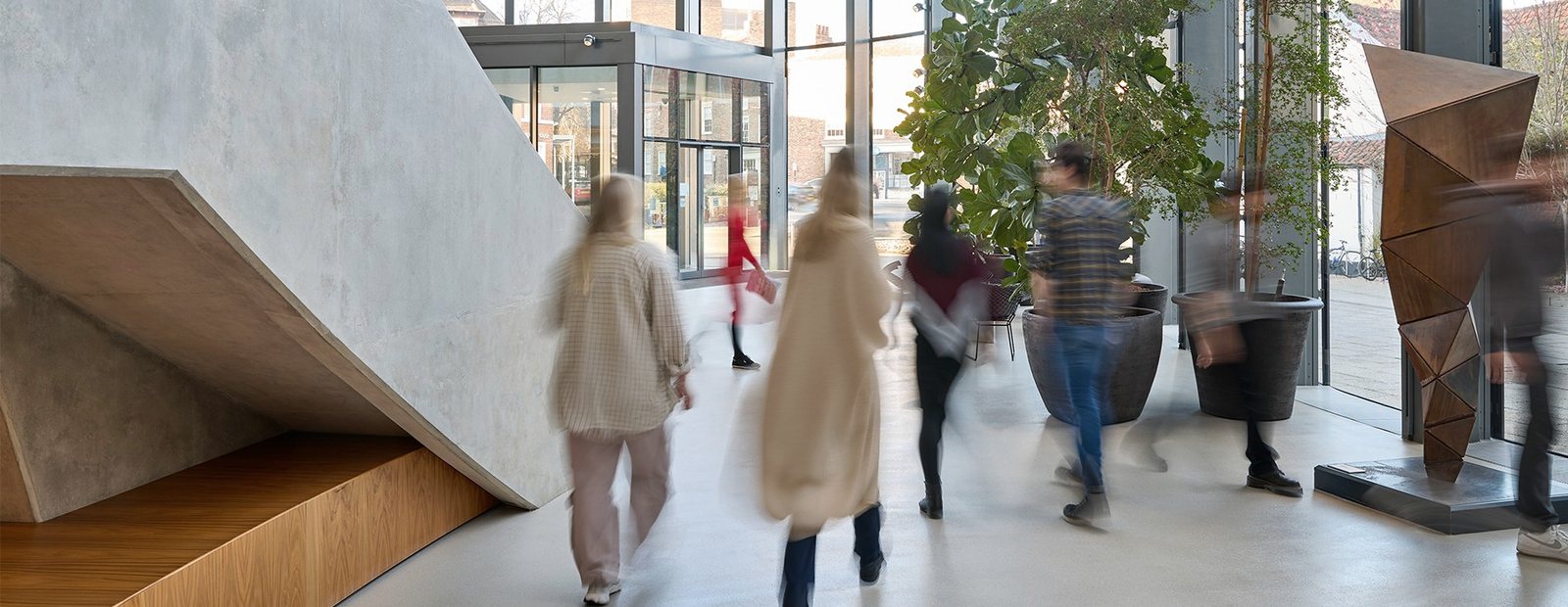 Helle Eingangshalle mit Menschen in Bewegung