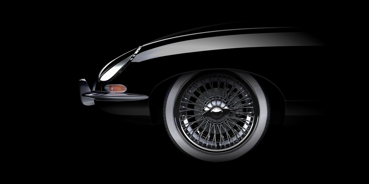 Frontpartie eines schwarzen Oldtimers mit Speichenrad