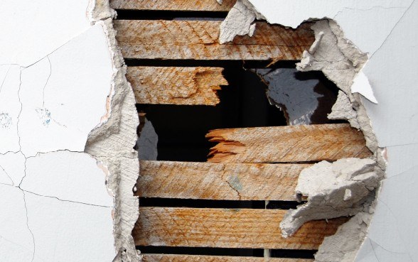 Aufgebrochene Wand mit freiliegenden Holzbohlen